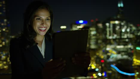 mujer de negocios latinoamericana llamada de video en el techo por la noche
