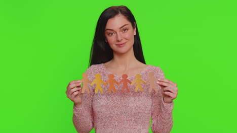 mujer sosteniendo muñecas de papel de diferentes tonos de piel, que representan la diversidad y la inclusión