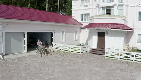 man grilling in a garage next to a house