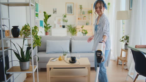 joyful woman cleaning house with vacuum