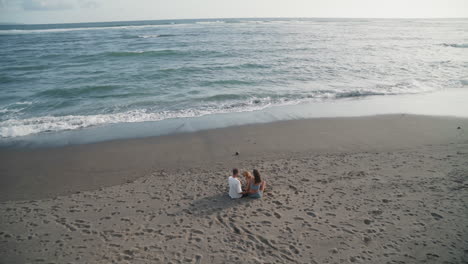 una pareja sentada en una playa desierta.