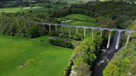 aerial view pontcysyllte aqueduct and river dee canal narrow boat bride in chirk welsh valley countryside pull back pan right