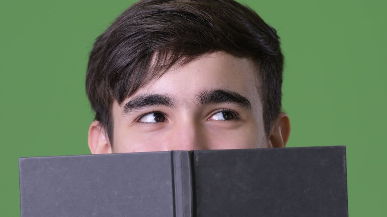 joven y guapo adolescente iraní contra un fondo verde