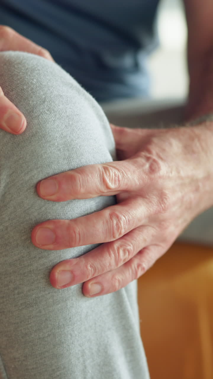 Close-up of Man's Hands Massaging a Painful Knee