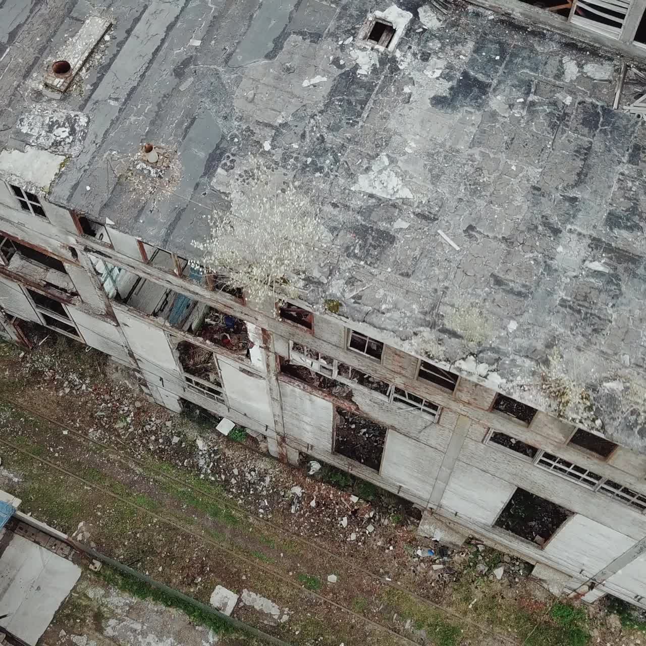 Flying over abandoned industrial factory buildings in very dilapidated condition. Old building for demolition.