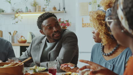 happy african american family chatting over holiday dinner at home