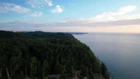 aerial flying past forest beach coastline out to gulf of gdansk during sunrise