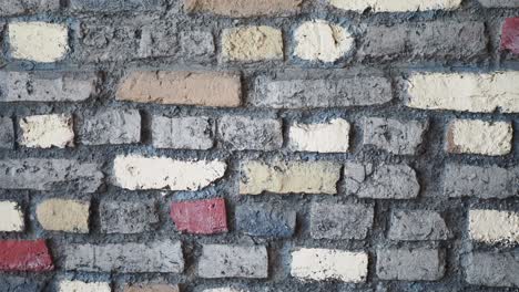 a close-up of a brick wall with various colors of brick and mortar