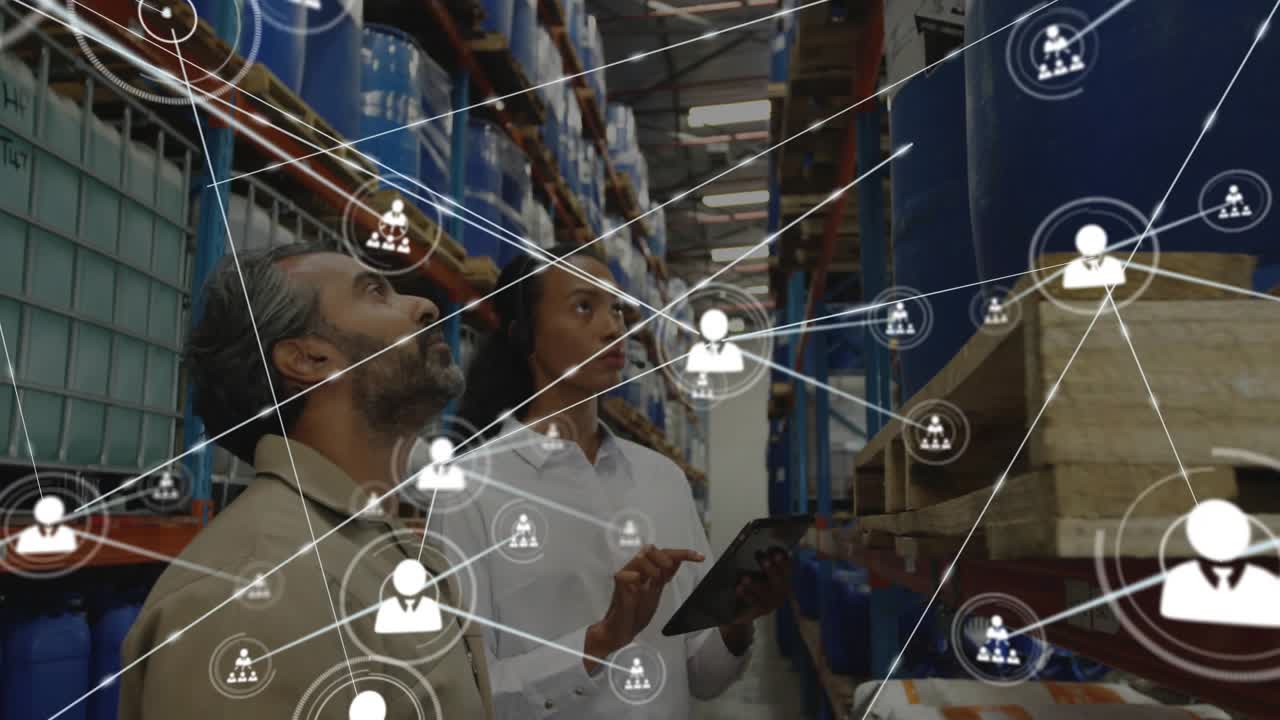 Logistics lead pointing while tech tapping tablet, starting network linking racks for inventory