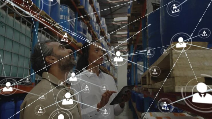 Responsabile della logistica che indica mentre un tecnico utilizza un tablet, avviando il collegamento di rete dei rack per l’inventario