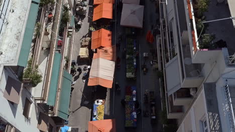 aerial drone shot pulling away from busy street market athens greece