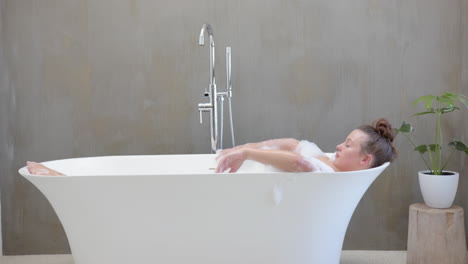 relaxing in bathtub, woman enjoying spa day with bubbles and peaceful ambiance