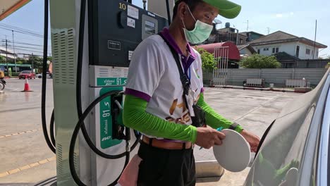 attendant refueling a vehicle at a gas station