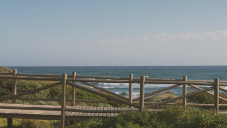 Male-Cyclist-On-A-Boardwalk-Towards-The-Beach-1