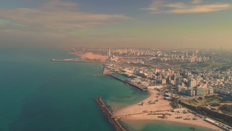 israel skyline from a drone early morning sunrise. panoramic aerial view above coastline of tel aviv modern and business city with hotels, seashore and beach. middle east skylines