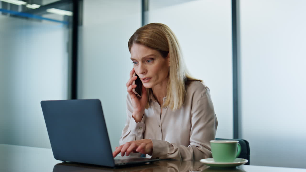 Sjokkert entreprenør ringer på telefon i arbeidsrommet. Begeistret vinner reagerer på gode nyheter.