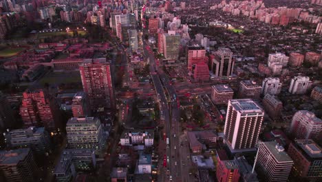 aerial drone fly above santiago city chile escuela militar metro station at dusk pink sunset, traffic at main avenue