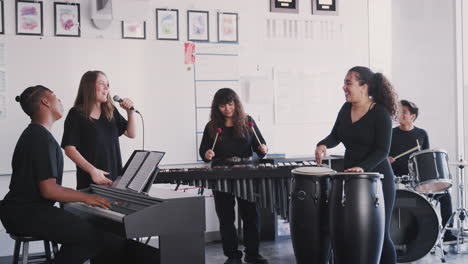 estudiantes de la escuela de artes escénicas tocando en la banda en el ensayo