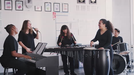 students at performing arts school playing in band at rehearsal