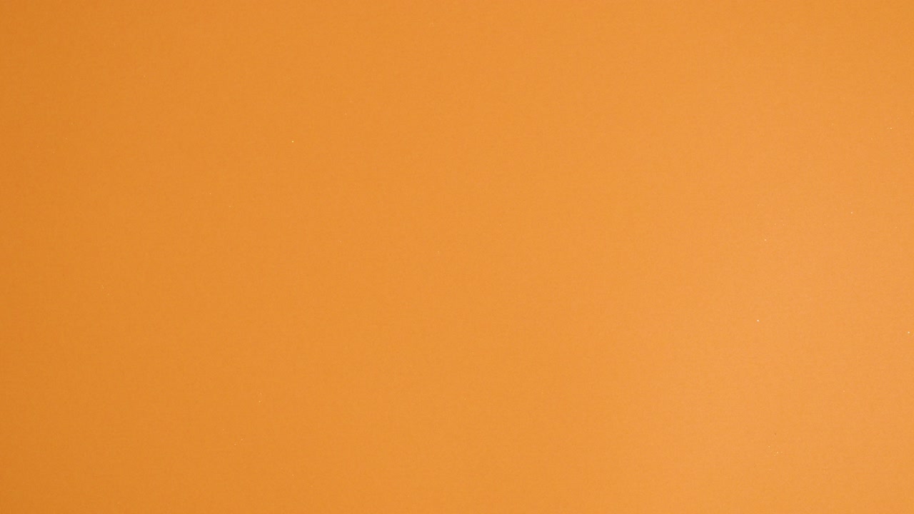 los huevos brillantes de pascua y las zanahorias hacen un patrón creativo en el fondo naranja.