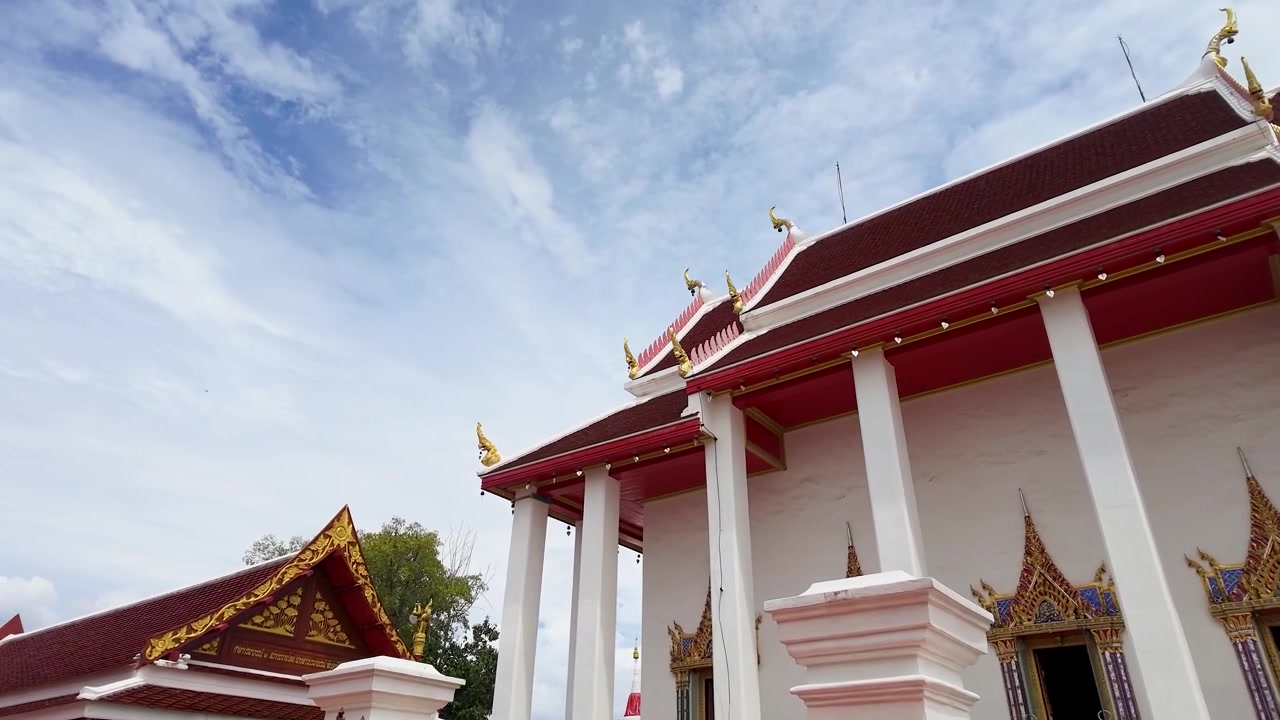 ภาพแพนมุมต่ำของวัดพุทธใต้ท้องฟ้าที่เต็มไปด้วยเมฆในจังหวัดนนทบุรี ประเทศไทย