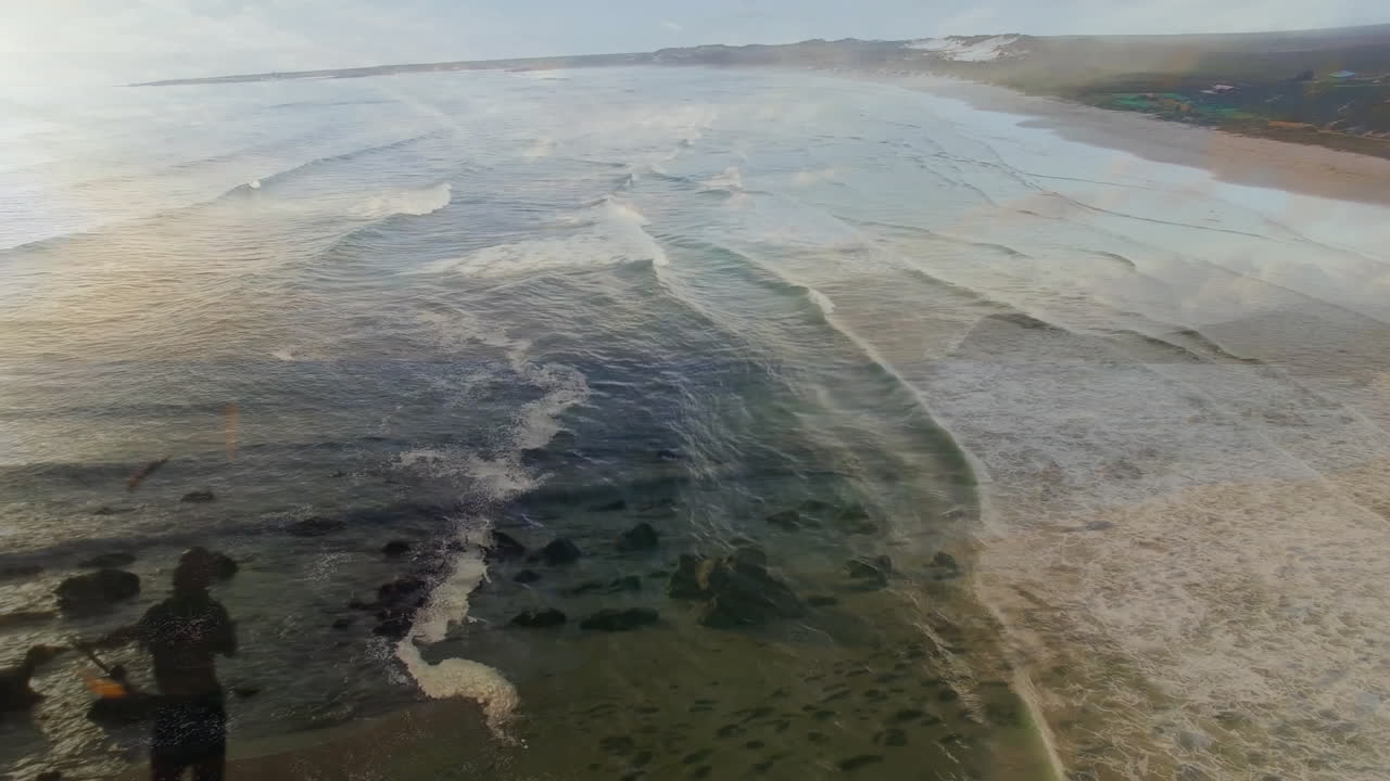 Waves crashing on sandy beach with distant coastline, creating serene animation