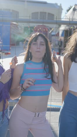 young women blowing bubble gum at an outdoor event