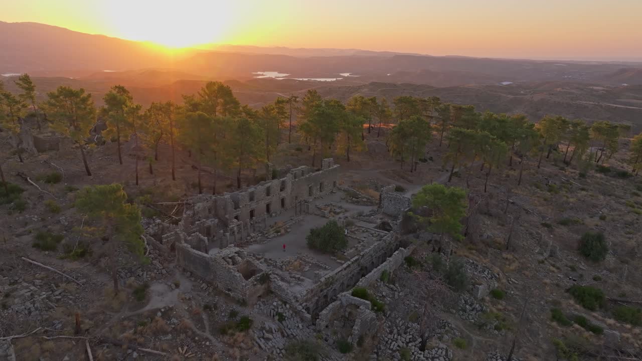 Vista de drone da luz do amanhecer sobre ruínas arqueológicas cercadas por árvores, Turquia