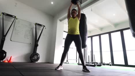 pregnant female fitness model doing body weight exercise in a gym to keep fit during her third trimester of pregnancy-1