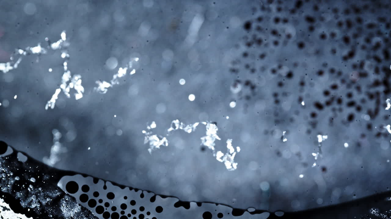 Primo piano di inchiostro che vortica e si mescola in intriganti motivi astratti.