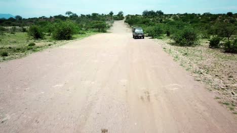 jeep viajando a través del paisaje en kenia - pullback