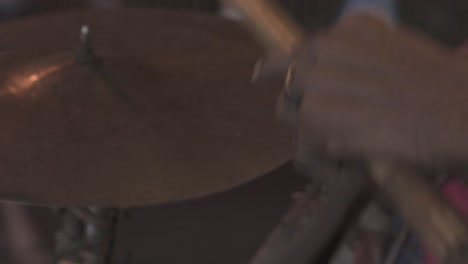 man with wooden sticks and bracelets plays rhythmic music