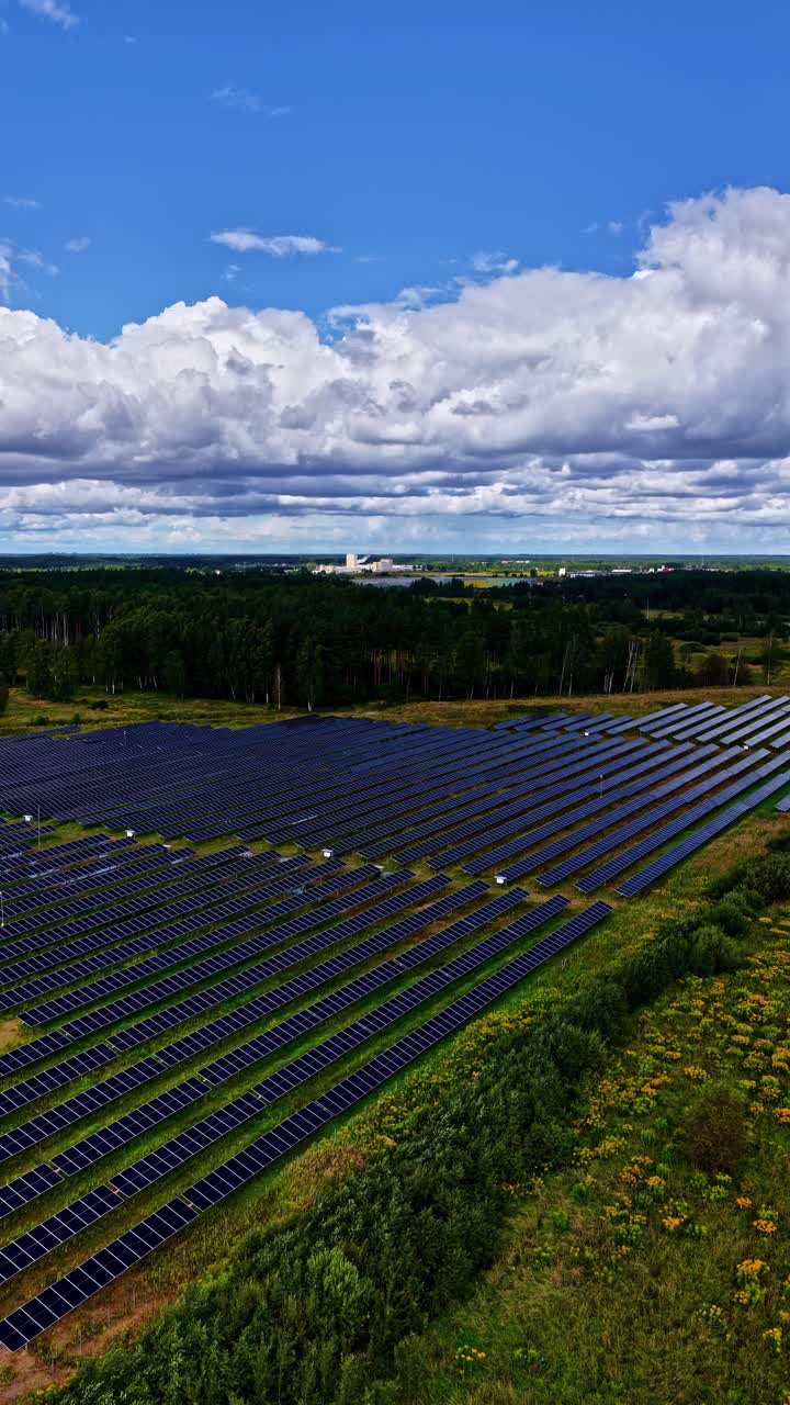 Solar panel farm renewable photovoltaic green energy field, aerial drone vertical video