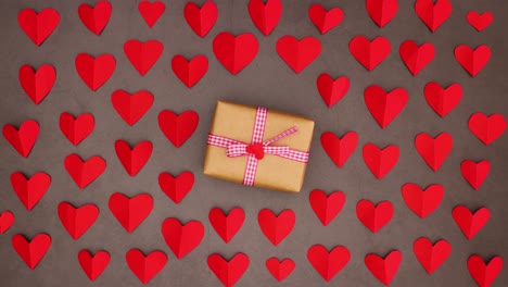 romántica caja de regalos para san valentín con cinta roja girando en círculo en el fondo con corazones - stop motion
