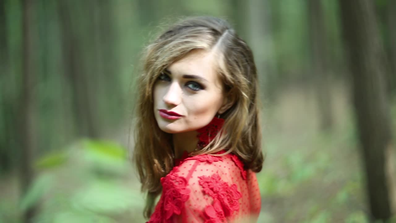 Beautiful Girl Walking In Forest. Beautiful girl in red long dress walking in forest