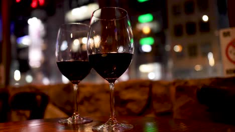 red wine glasses with blurred urban background