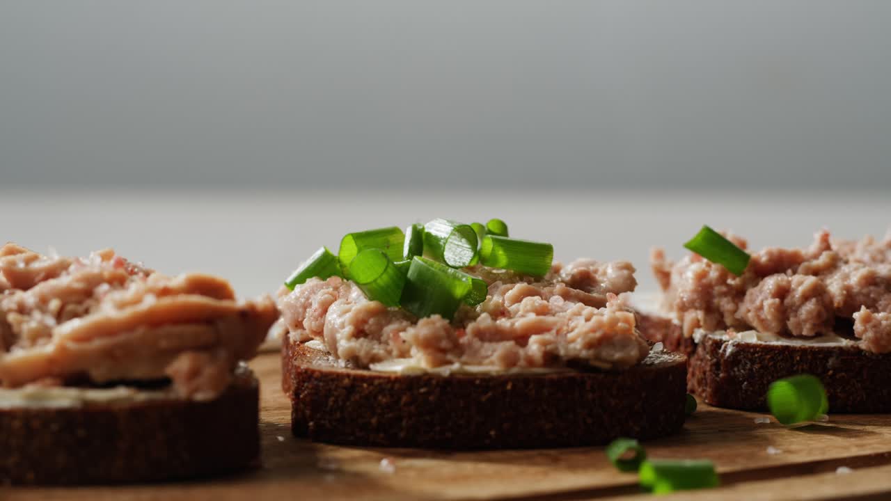 Smoked cod liver in oil in open tin can with fresh greens on wooden table. Seafoods delicacy. High quality 4k footage