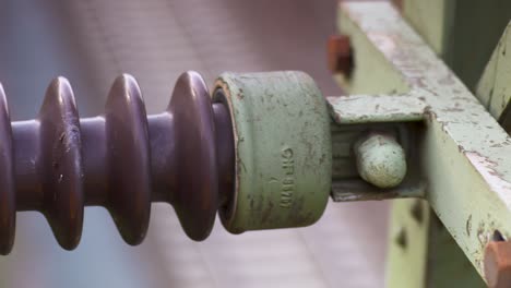 close-up of a weathered ceramic insulator on a power line, detail-rich texture visible