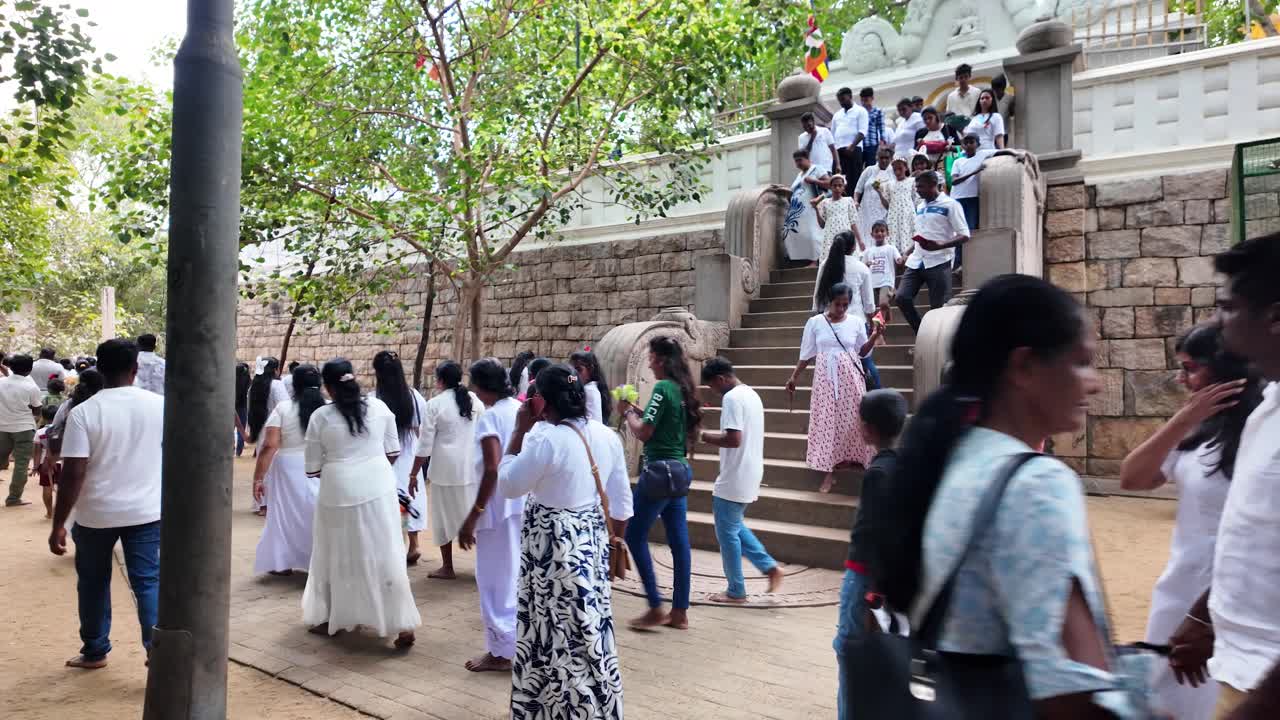 A bustling scene of people gathering at the sacred Jaya Sri Maha Bodhi in Anuradhapura, Sri Lanka, showcasing cultural and spiritual significance in a lively atmosphere.