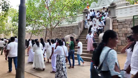 a bustling scene of people gathering at the sacred jaya sri maha bodhi in anuradhapura, sri lanka, showcasing cultural and spiritual significance in a lively atmosphere.