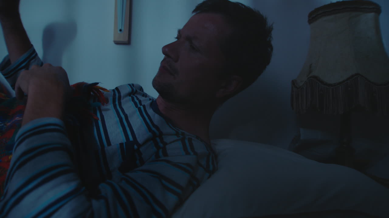 Man relaxing in bed at night