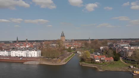 countenance aerial view of pleasure boat harbor and traffic along and on the cityscape boulevard of zutphen with walburgiskerk cathedral towering behind and reinforced wall in foreground