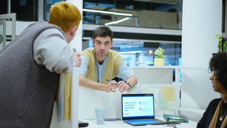 young office workers chatting over cubicle wall during workday