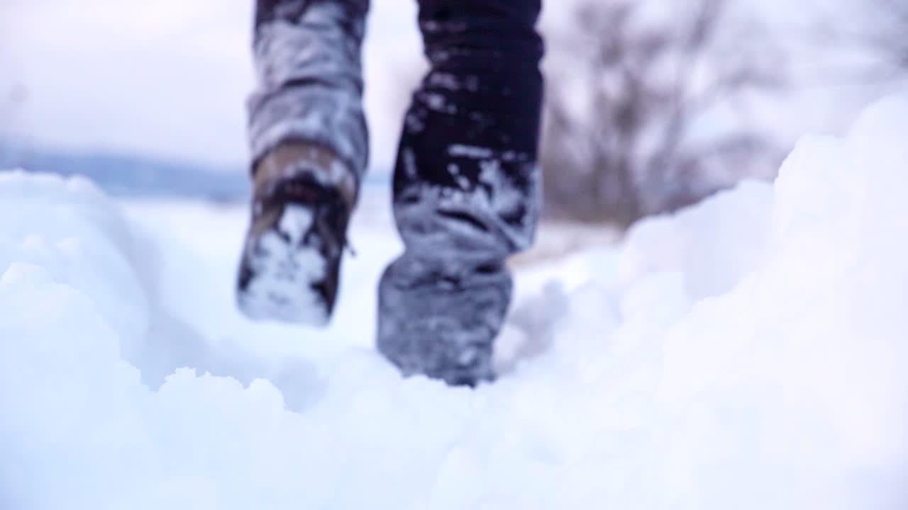 Low angle shot of walking on snow in slow motion