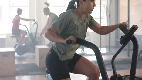 Mujer-Caucásica-Determinada-E-Inalterada-Entrenando-En-Bicicleta-Elíptica-En-El-Gimnasio,-En-Cámara-Lenta