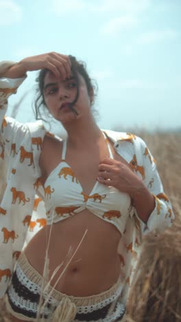 young woman posing outdoors in a tiger-patterned bikini with a carefree expression
