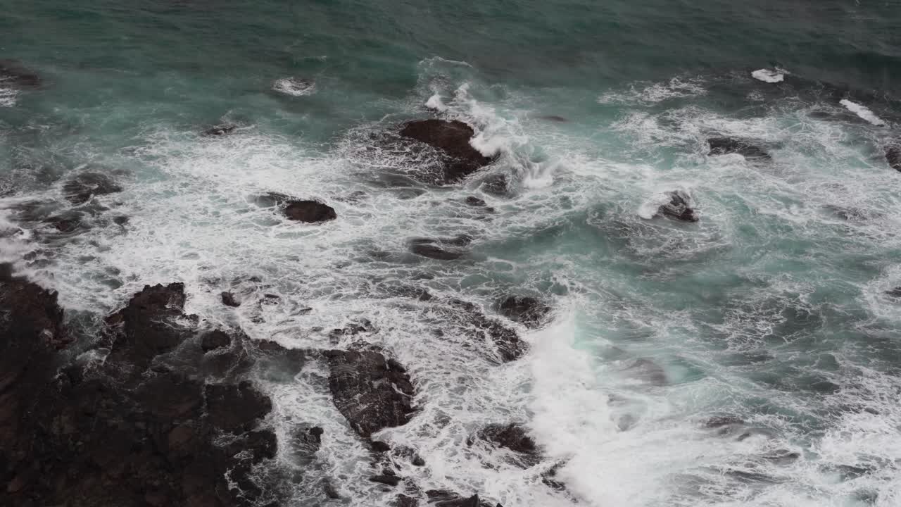 Filmato tranquillo e rilassante di bellissime onde blu dell'oceano che si infrangono sulla costa rocciosa alla Gola di Loch Ard, Costa dei Dodici Apostoli ed entroterra di Port Campbell