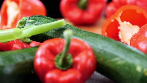 Fresh-vegetables-with-peppers,-leeks,-carrots-and-leeks-lying-on-wooden-chopping-board,-close-up