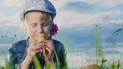 niña de 7 años comiendo helado en prado verde 03