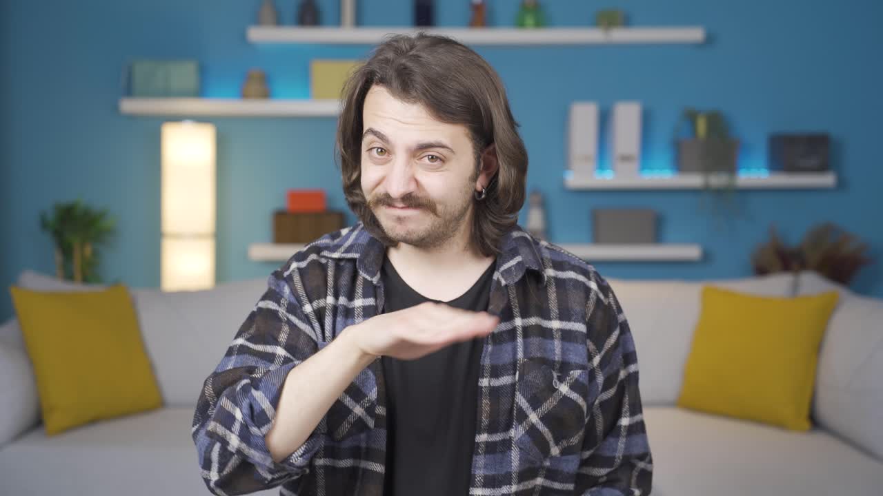 카메라를 바라보는 남자가 마이너스 기호를 만들고 있습니다.